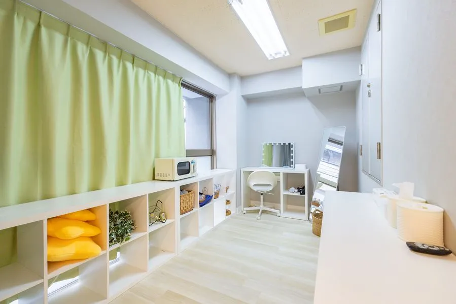 Moff room三ノ宮店の設備スペース。棚に電子レンジと収納ボックスが並び、奥にライト付きのドレッサーと姿見がある