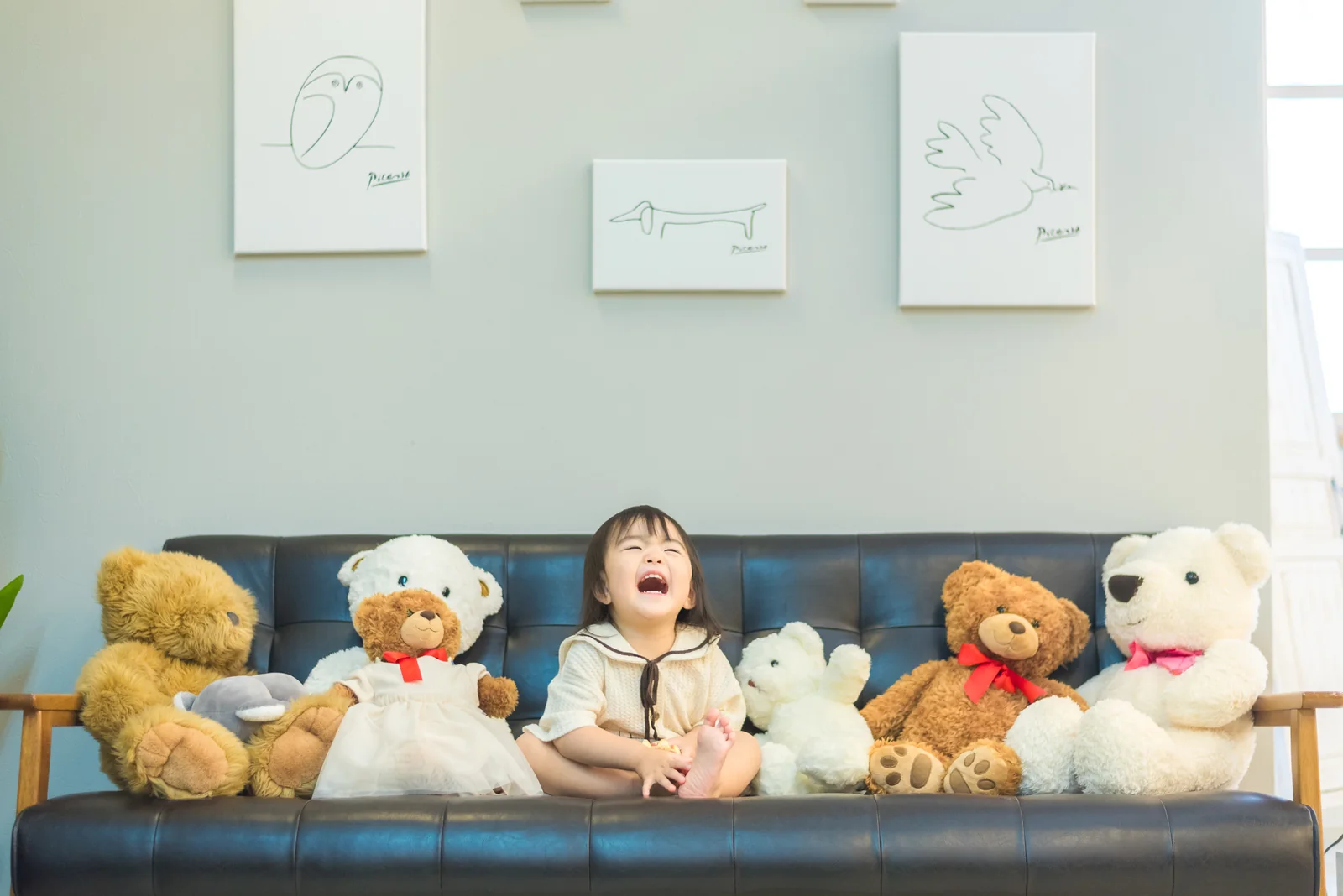 三ノ宮店のソファで、複数のくまのぬいぐるみに囲まれて座る子ども