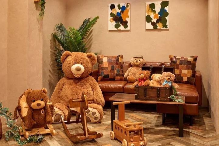 下北沢店の革のソファと、くまのぬいぐるみ、木のおもちゃが並ぶ一角